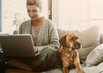 woman working from home with her dog on the sofa