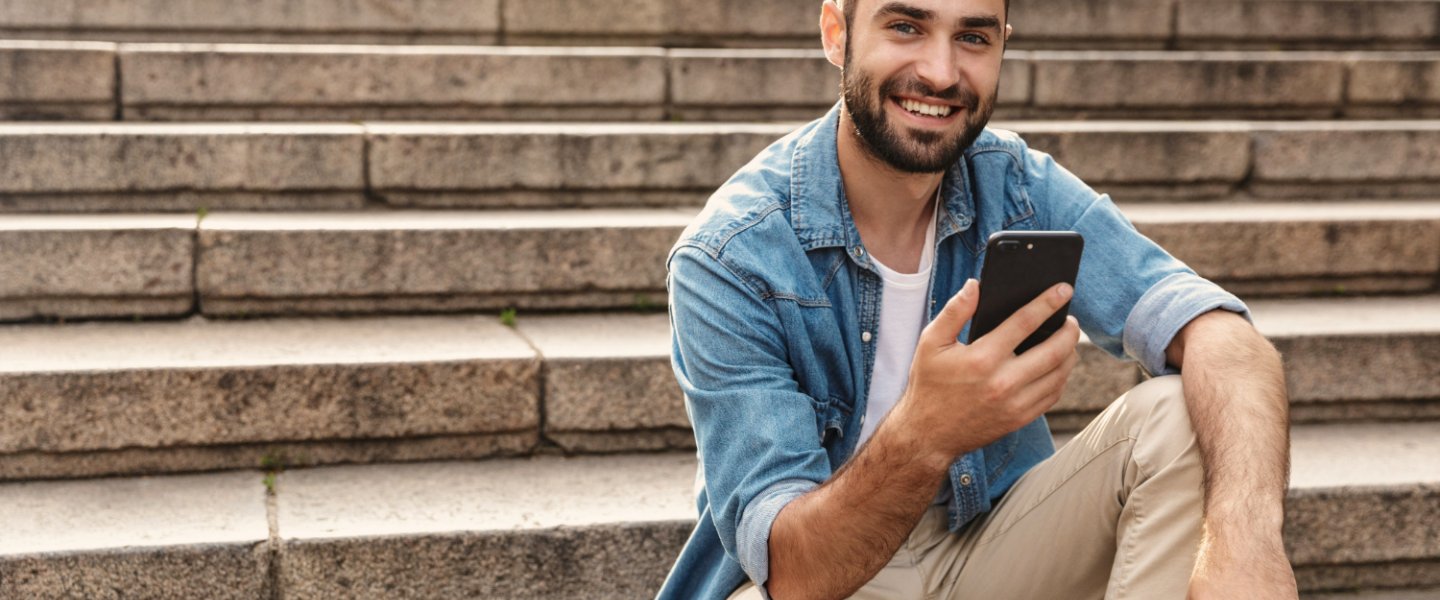 man with smartphone sits on stairs